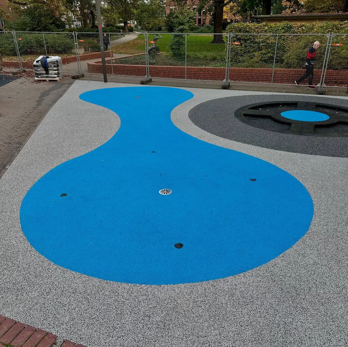 Frei geformte himmelblaue Fläche in lichtgrauem Belag