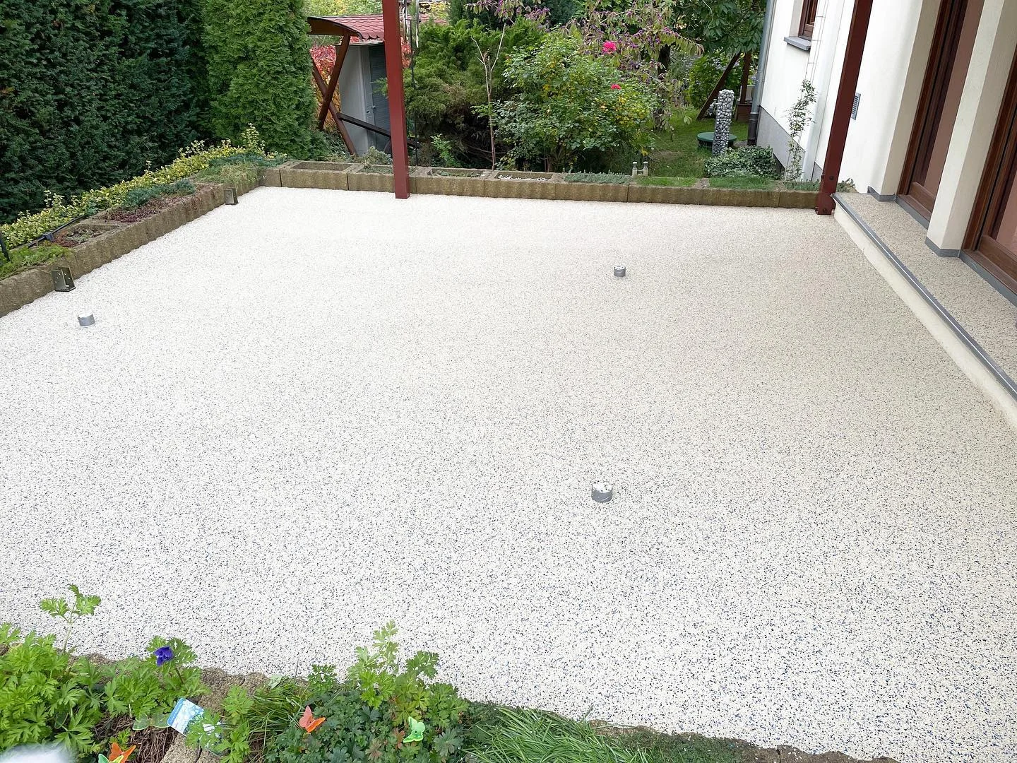 Perlweiße Fallschutzfläche mit 10 % Grau auf einer Terrasse