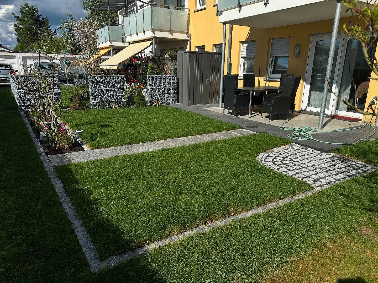 Fertig angelegter Privatgarten mit Rasenfläche, Plattenweg und Gabionen