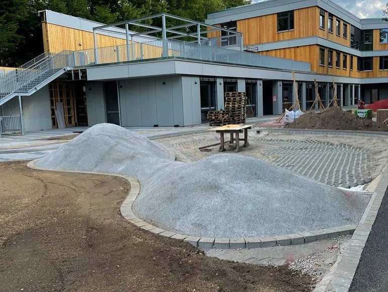 Baustelle mit vorbereiteten Flächenformen aus Schotter vor dem Belagseinbau