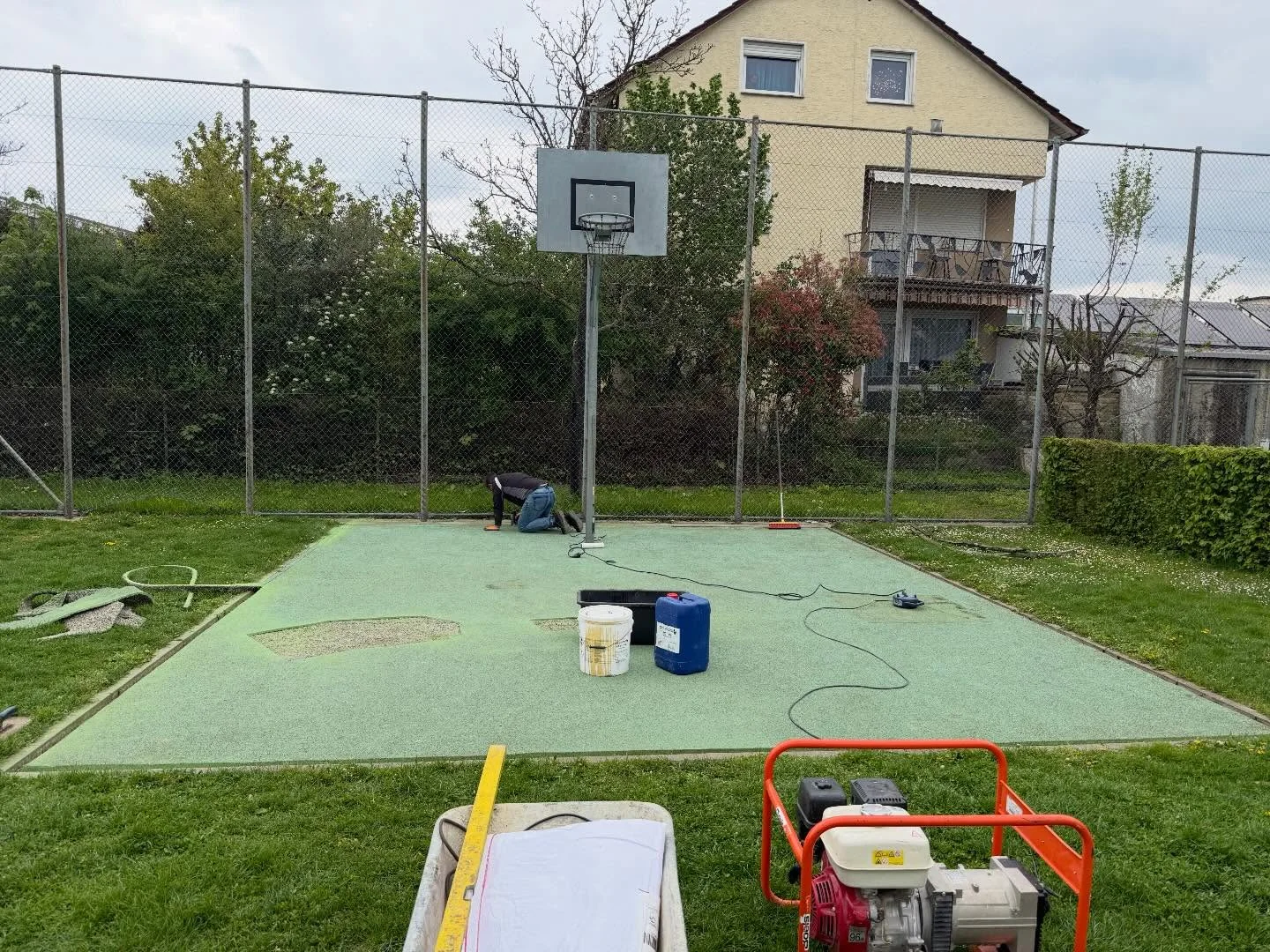 Sanierung eines Spielfelds mit Basketballkorb