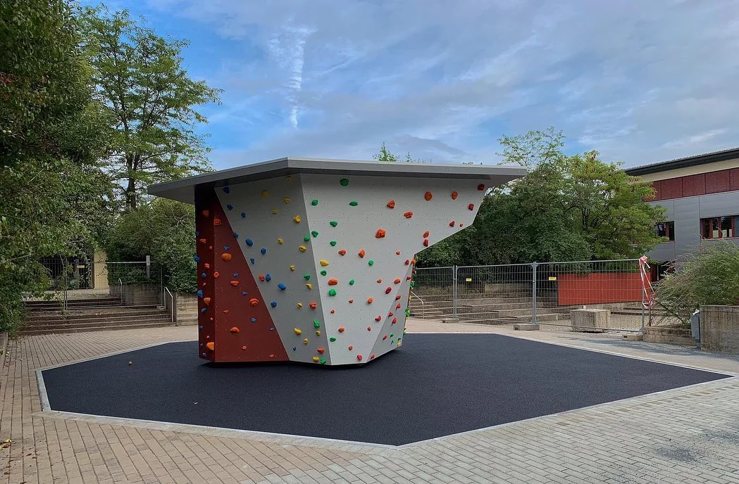 Kletterturm auf schiefergrauer Fallschutzfläche